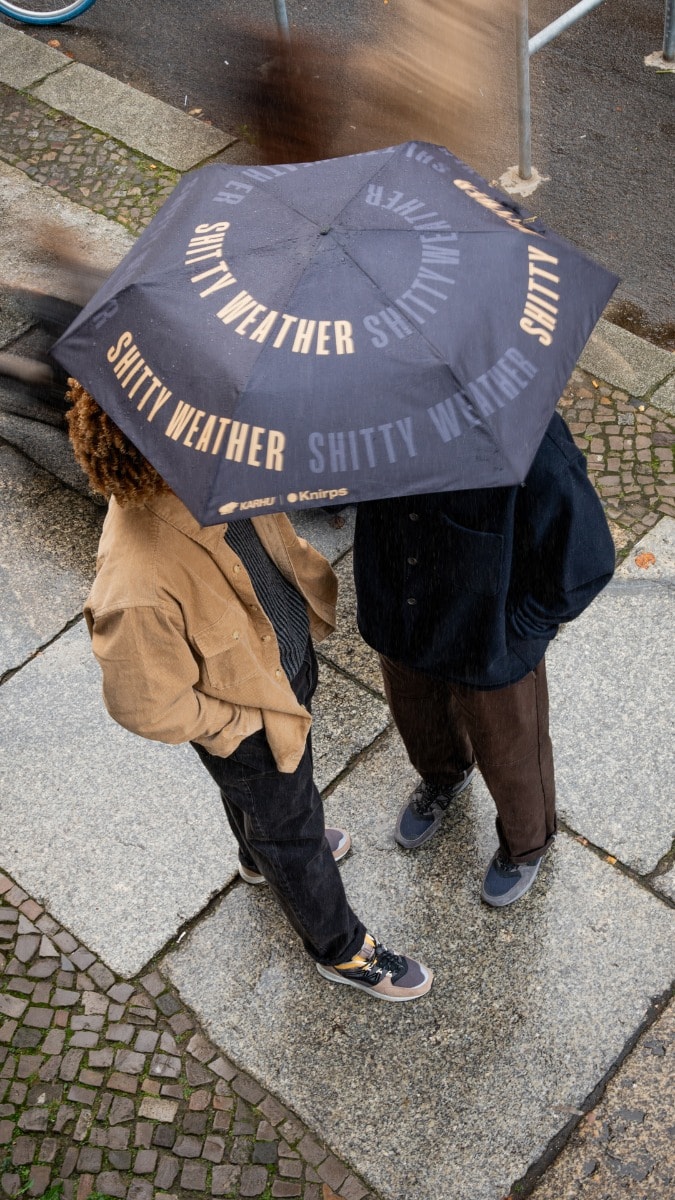 Zwei Personen unter Knirps Karhu Taschenschirm Zwei Personen unter Knirps Karhu Taschenschirm